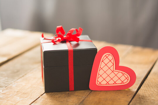 Image of Valentine's day, symbols of love, gift box on a background of wooden planks.
