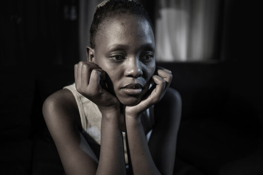 teen African American girl at night suffering depression - dramatic artistic portrait of young attractive sad and depressed black woman worried and upset alone in the dark