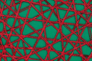 Twisted red ribbon table mat on green background