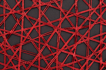 A decorative placemat made of twisted red ribbon on black  background