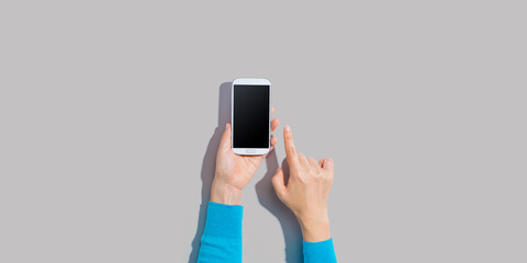 Person using a white smartphone - overhead view