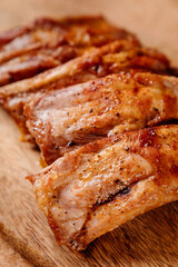 fried with spices pork ribs in a glass baking sheet on a wooden cutting board. cooked meat at home. Barbecue.