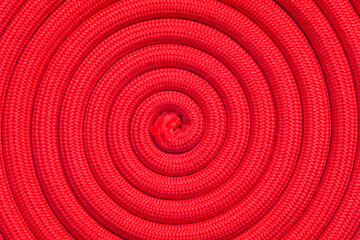 Twisted red rope. Full frame of rope arranged in a spiral shape