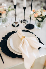 decoration of a wedding table, table setting for a wedding, white dishes on a wedding table with elements of gold leaves, themed decor