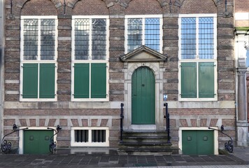 Naklejka premium Historic Building Facade with Green Wooden Shutters in Amsterdam, Netherlands