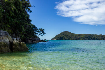 Fototapeta na wymiar panoramic view of a tropical beach with turquoise water and white sand in abel tasman national park, new zealand