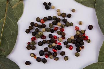 bay leaf with peppercorns on a white background