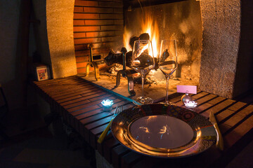 Concept ambiance hygge au coin du feu avec vaisselle de fête pour repas. Calme et sérénité,...