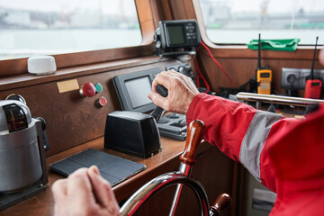 Yacht skipper standing at the steering wheel