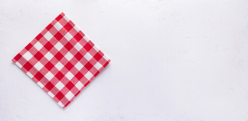 Checked or checkered tablecloth at stone surface of table. Top view of cloth napkin texture background