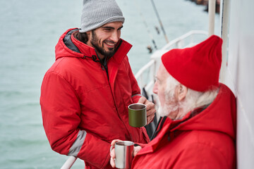 Two colleagues drinking coffee in the morning at the boat
