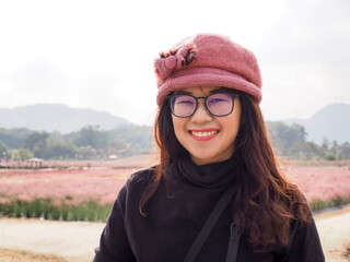 happy woman in winter costume at flower garden