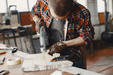 Wood cutting with circular saw. Closeup of mature man sawing lumber.