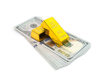 gold bars on a pile of US dollar banknotes