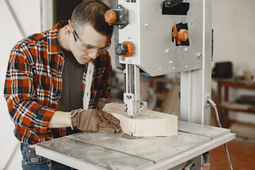 Wood cutting with circular saw. Closeup of mature man sawing lumber.