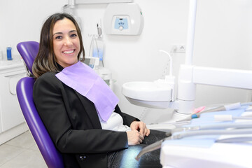Portrait of smiling young woman lying in dental chair and looking at camera, copy space. High quality photo