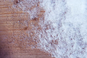 fresh snow crystals on the weathered wooden surface in sunny and frosty day  - winter close up, frozen nordic background 