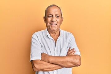 Handsome mature man wearing casual white shirt happy face smiling with crossed arms looking at the camera. positive person.