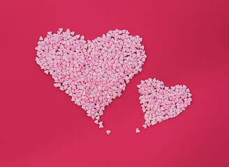 Two big hearts made of small hearts on red background. Love minimal concept