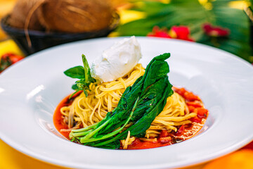spaghetti with spinach and sour cream on a decorated table