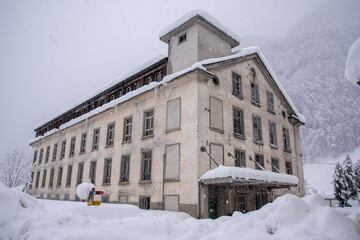 old abandoned textile factory in the middle of the snow, in Diesbach, Glarus, Switzerland