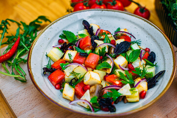 healthy food. Salad with zucchini, tomatoes, herbs and pomegranate seeds on a decorated table