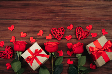 Red roses and hearts on a dark wooden background. Valentine's day postcard concept.