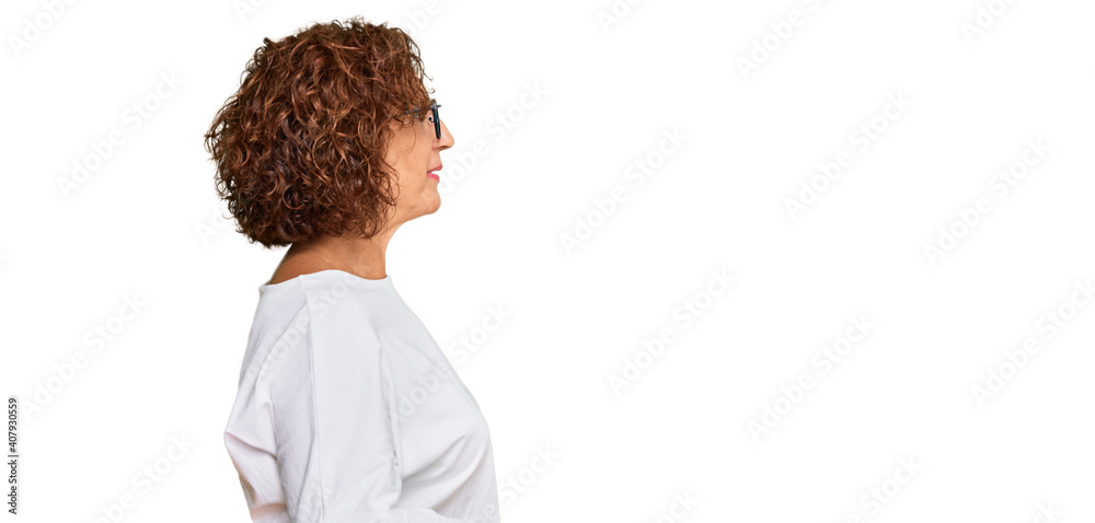 Poster beautiful middle age mature woman wearing casual clothes and glasses looking to side, relax profile 