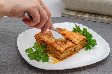 Beef lasagna served with fresh parsley close up on plate.
