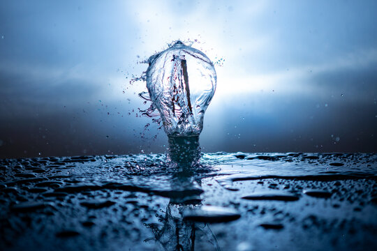 Light bulb with water splashes on a blue background - energy concept
