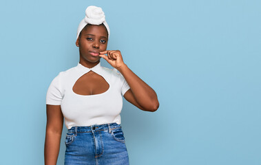 Young african woman with turban wearing hair turban over isolated background mouth and lips shut as...