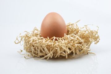 Chicken eggs in nest of straw. Isolated on white background.