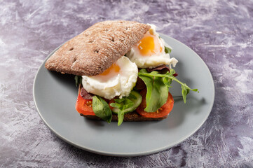 Sandwich with eggs and herbs. Burger loaf and poached eggs.