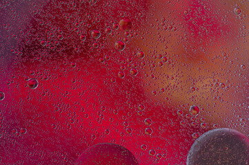 Oil droplets in water against a colored background