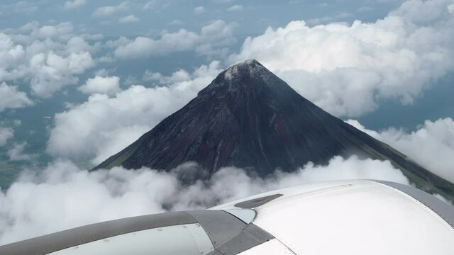 Aerial view of Mount Mayon volcano seen from airplane window near Legazpi City, Albay, Philippines. 