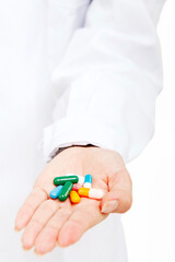 The young female doctor holding a pill