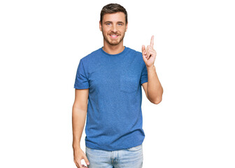 Handsome caucasian man wearing casual clothes showing and pointing up with finger number one while smiling confident and happy.