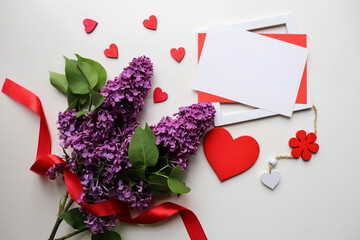Fototapeta na wymiar happy valentine's day card. spring bouquet of lilacs on white background and red heart