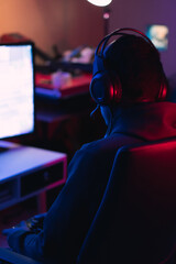 Shallow focus of a male gamer with headphones streaming a live video game online while playing © Eduardo Sandoval/Wirestock