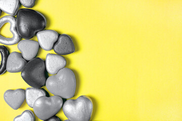 Gray hearts on a yellow background, trending colors of 2021. Copy space, modern Valentine's Day concept.