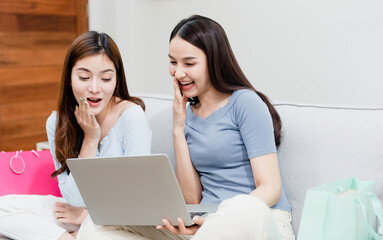 Two Asian beauty people are looking laptop. With a happy smiling face, being a new normal online business In the shopping experience from home