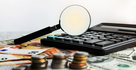 Calculator and magnifying glass. Office equipment at workplace. Conceptual image of desk work, financial paperwork and business economy.