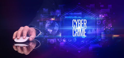 hand holding wireless peripheral with CYBER CRIME inscription, cyber security concept