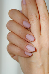 Female hands with new manicure in sunbeams on a blurred light background. Selective focus