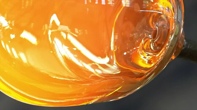 Glass handmade production, golden ball of hot glass.