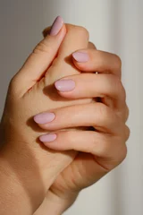 Female hands with new manicure in sunlights on a blurred light background