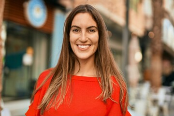 Young hispanic woman smiling happy standing at the city.