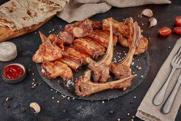 Grilled meat platter BBQ, textured dark background
