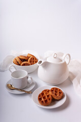 Waffles with honey, tea, teapot on a white background.