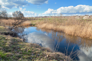 Fototapeta na wymiar Spring river, perfect reflection of bright blue sky.